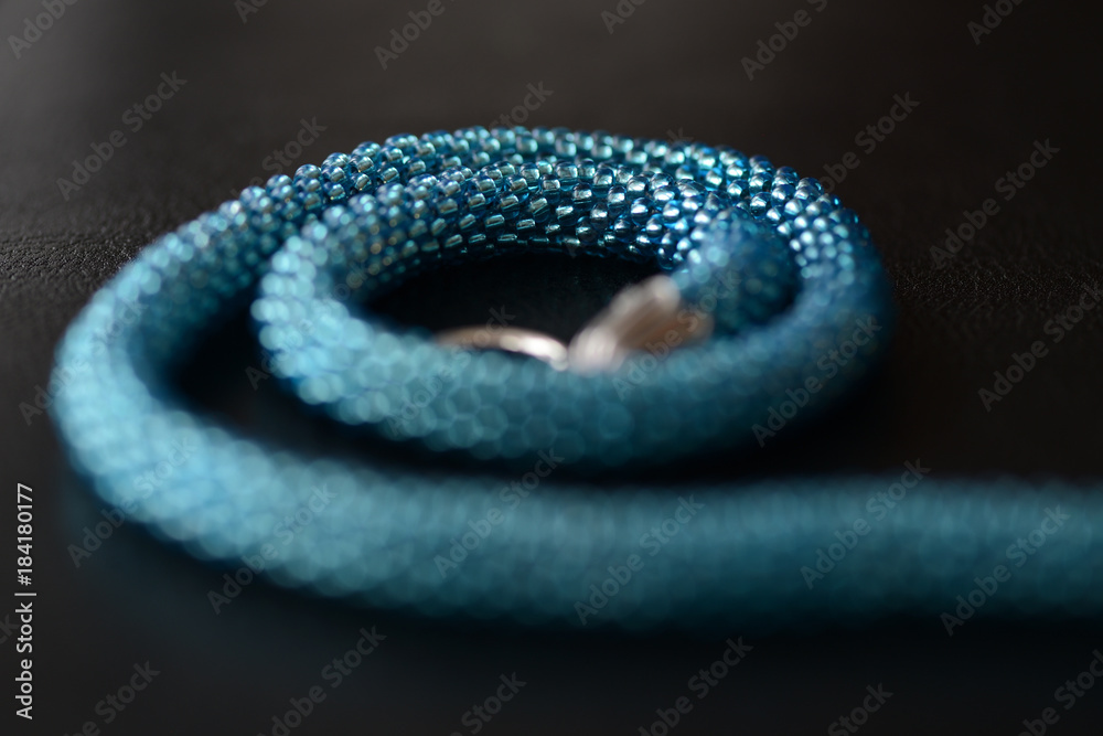 Obraz premium Beaded necklace of turquoise color on a dark background close up