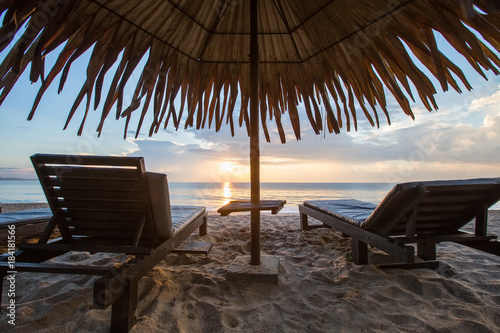 Sun loungers with umbrella on the beach, sunrise