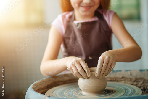 Hands of young potter, close up hands made cup on pottery wheel photo