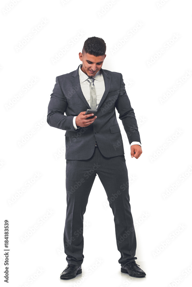 A handsome businessman in an elegant suit with a mobile phone in his hand.