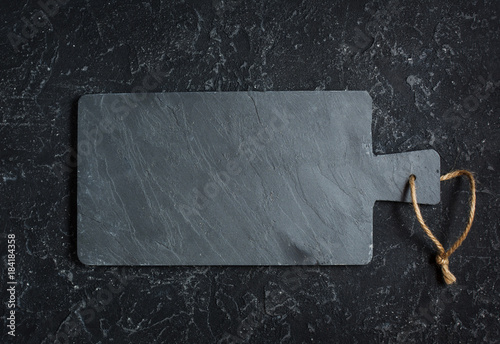 Принти на полотні Black old-fashioned stone and slate cutting board on black background