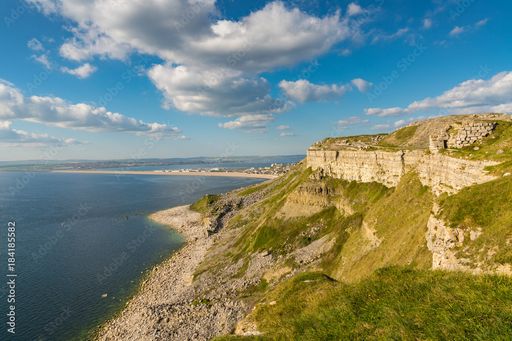 View from the South West Coast Path  towards Fortuneswell and Chesil Beach, Isle of Portland, Jurassic Coast, Dorset, UK - with clouds over Weymouth in the background