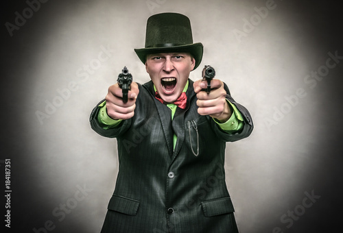 The spy. Secret service. Angry Detecive agent holds pistol gun in his hands aiming and attack. Retro wicked gangster isolated on white background.