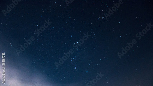 Constellation of the orion on a beautiful, night, starry sky with clouds.