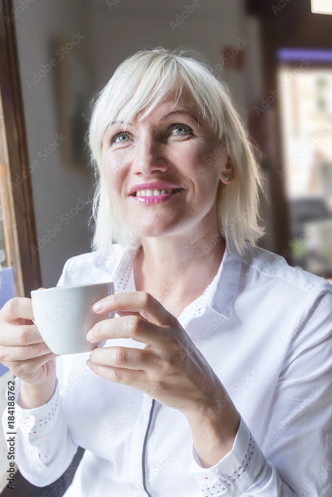 Portrait of a beautiful young blonde woman enjoying tea cup. Portrait of a beautiful young blonde woman enjoying tea cup.