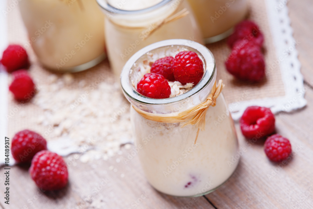 Jars with yogurt, raspberries and oat flakes Jars with yogurt, raspberries and oat flakes