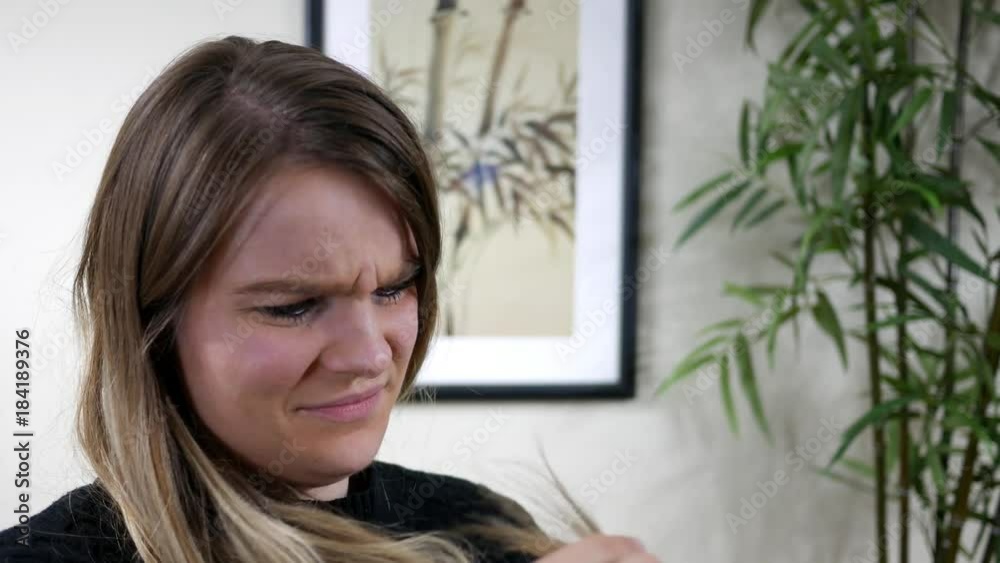 Portrait of beautiful brunnette woman looking at her split ends in her hair ALT Portrait of beautiful brunnette woman looking at her split ends in her hair ALT