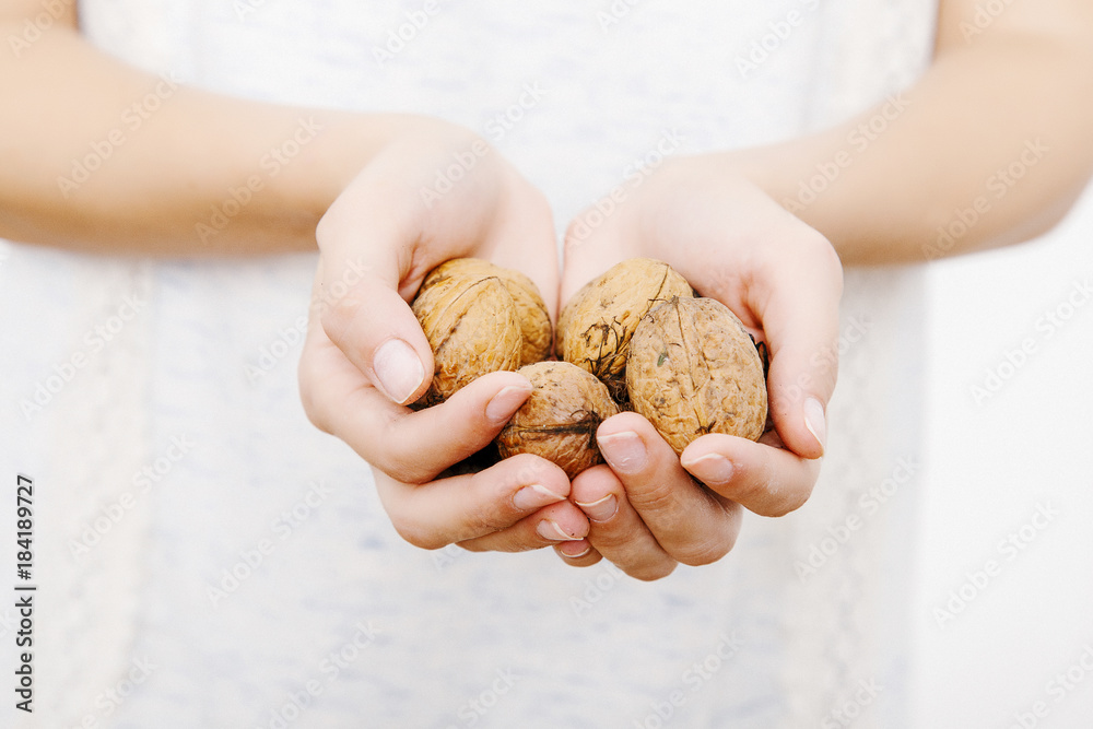 The girl keeps the Greek nuts in her hands.