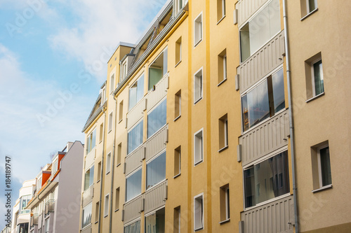 yellow apartment house with glassed balcony