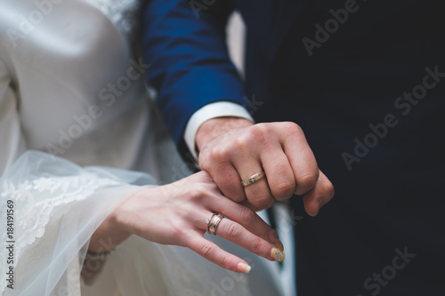Gold and silver wedding rings on couple;s hands
