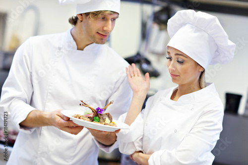 Busy chefs at work in the restaurant kitchen photo