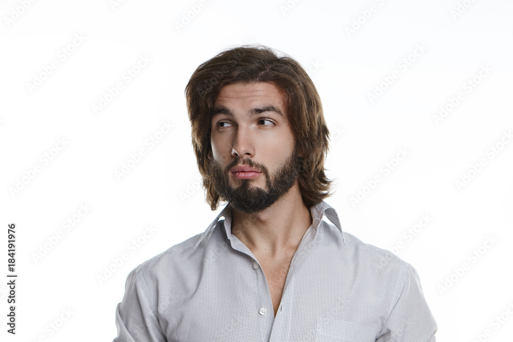 Handsome guy with stylish haircut and fuzzy beard looking sideways having suspicious skeptical expression. Bearded young man in grey shirt expressing suspicion, doubt or distrust posing in studio Handsome guy with stylish haircut and fuzzy beard looking sideways having suspicious skeptical expression. Bearded young man in grey shirt expressing suspicion, doubt or distrust posing in studio
