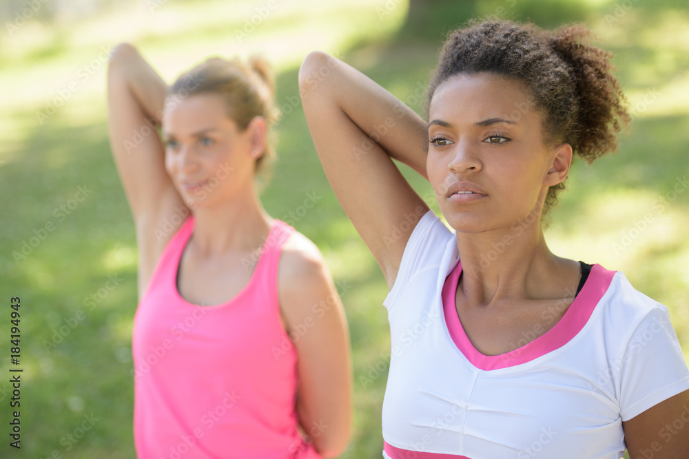 two girlfriends having arms stretching exerciseq two girlfriends having arms stretching exerciseq