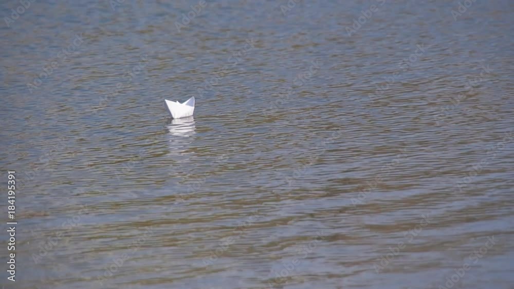A paper boat is floating on the water. A paper boat is floating on the water.