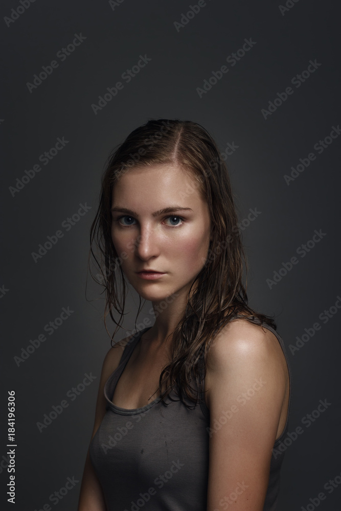 portrait of a beautiful sexy women with wet hair in the gray shirt on gray background portrait of a beautiful sexy women with wet hair in the gray shirt on gray background