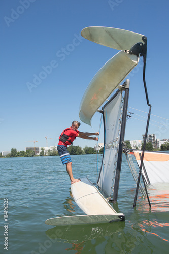 salior trying to right his catamaran after capsize photo