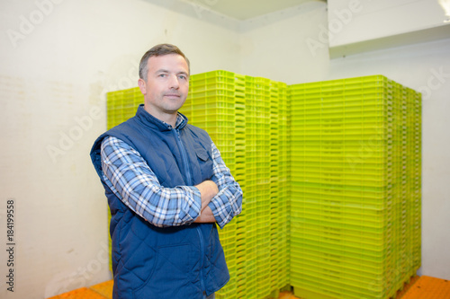 Portrait of man next to stack of plastic containers