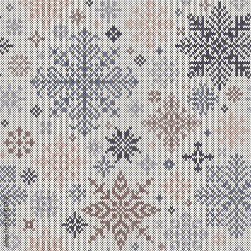 Seamless knitted pattern from gray and beige snowflakes