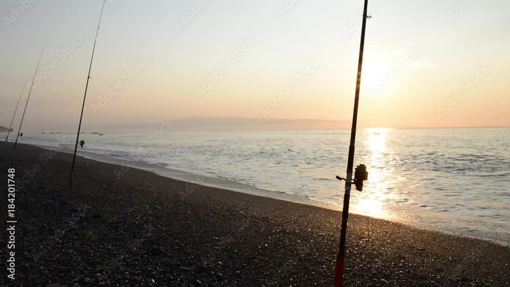 pesca sulla spiaggioa alle prime culi del giorno con mare piatto