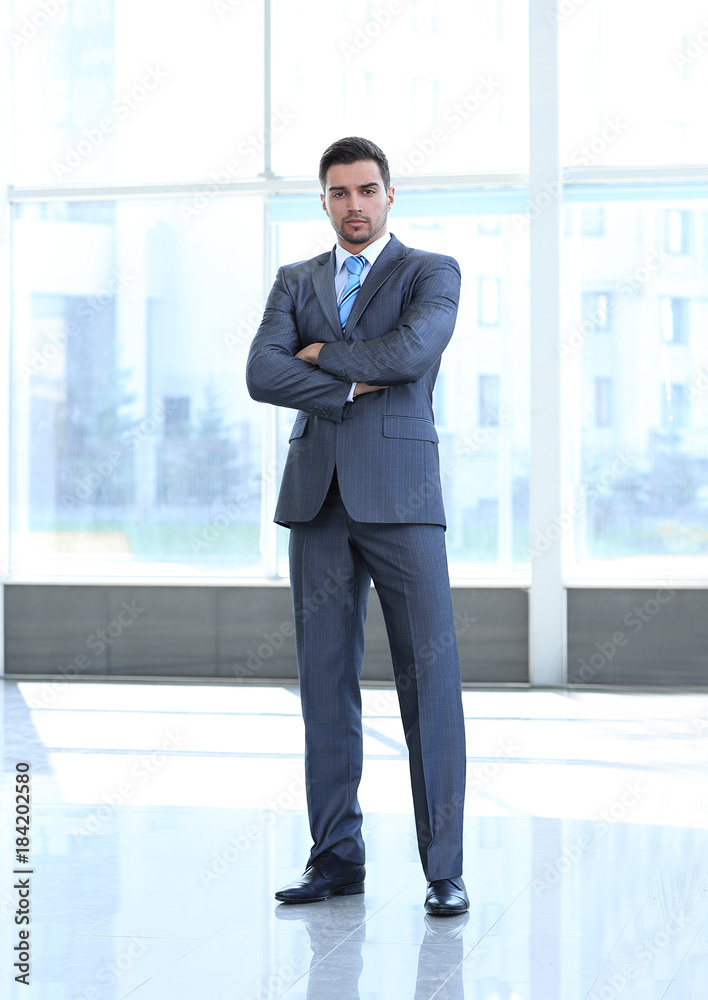portrait in full growth. confident businessman standing in the spacious lobby portrait in full growth. confident businessman standing in the spacious lobby