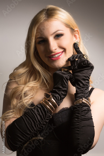 Closeup portrait of smiling young woman in sexy black corset and silk gloves