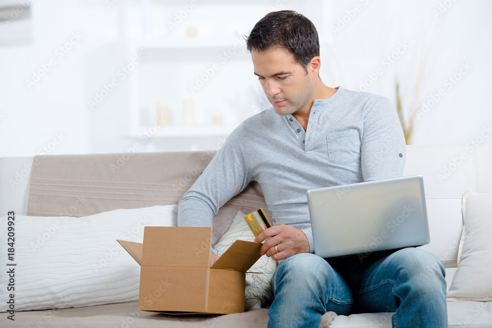 man unpacking online purchase at home man unpacking online purchase at home