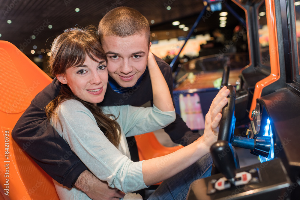 young couple cuddling in race car simulator