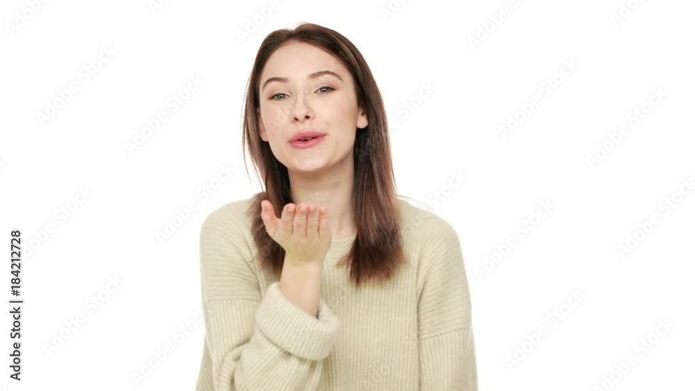 Portrait of gorgeous brown-haired woman expressing love and affection giving air kiss to her beloved over white background closeup. Concept of emotions Portrait of gorgeous brown-haired woman expressing love and affection giving air kiss to her beloved over white background closeup. Concept of emotions