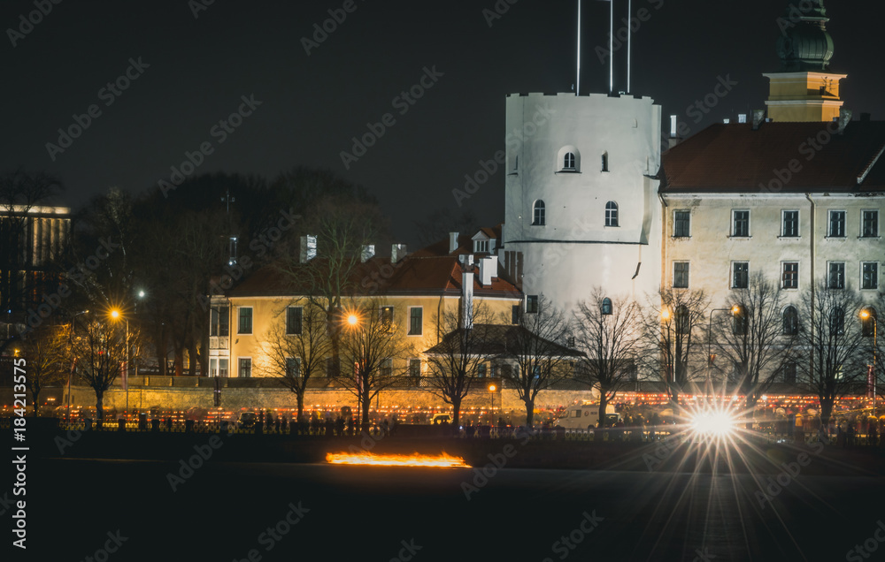 Obraz premium Latvian patriots lighting candles as a tribute to fallen freedom fighters. An annual remembrance day in 11th of November