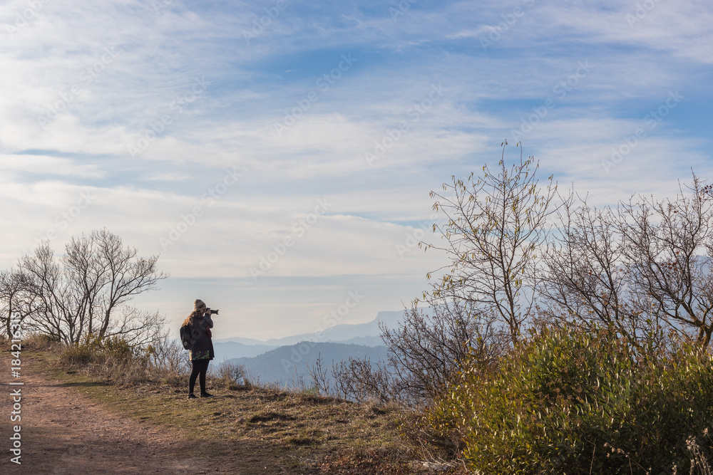 Woman photographing surreal landscape high in the mountains of Siurana, Spain Woman photographing surreal landscape high in the mountains of Siurana, Spain