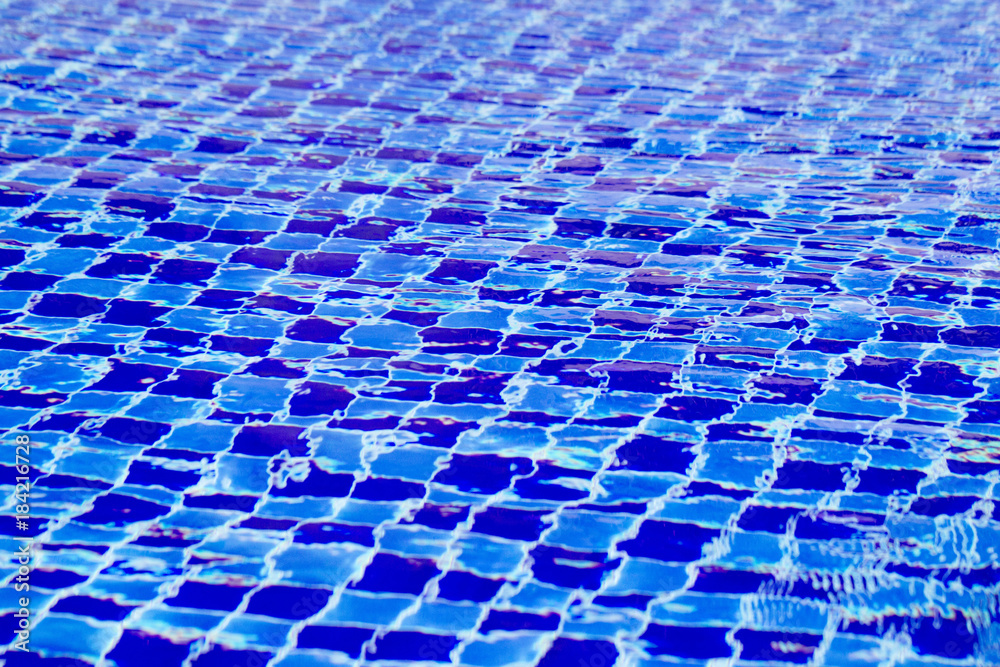 Fototapeta premium Abstract background from blue tiled pool with clear rippling water