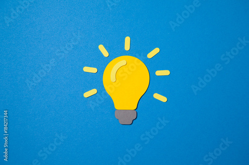 Paper light bulb as a symbol for creativity on a blue background