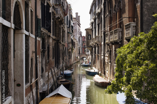 View of boats on canal and old, typical, historical buildings in Venice / Italy. © theendup
