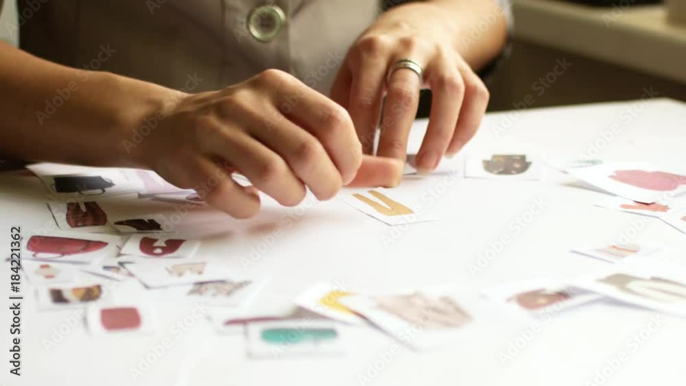 The stylist is working on the selection of the image. Work with paper material in style selection The stylist is working on the selection of the image. Work with paper material in style selection