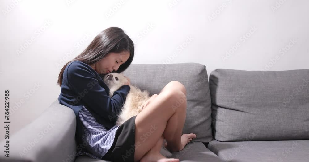 Crying woman at home and dog licking  her