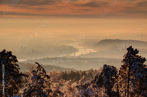 Photography Glowing sunrise over Budapest in winter morning mist with Danube riverbank and b