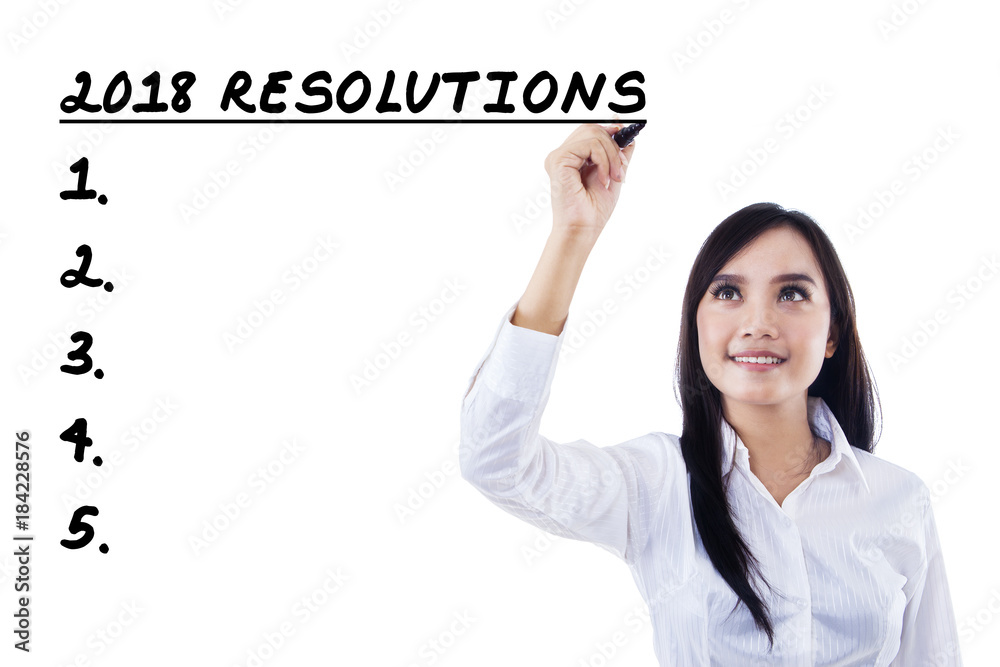Businesswoman writing a list resolutions for 2018 Businesswoman writing a list resolutions for 2018
