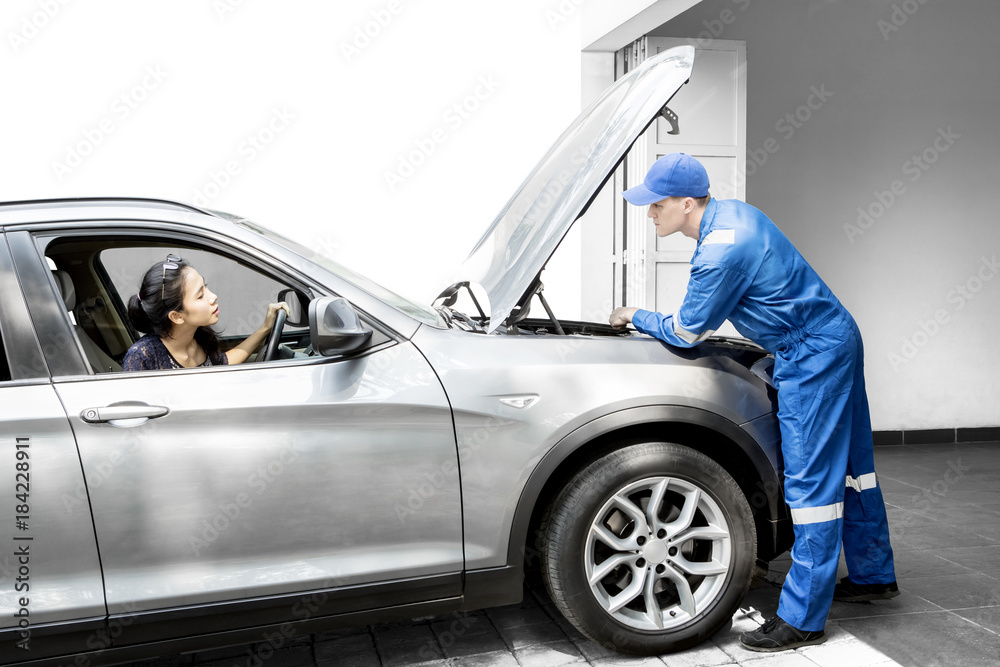 American mechanic discussing with his customer