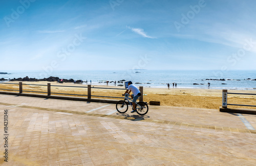 Middle-aged man biking by the sea photo