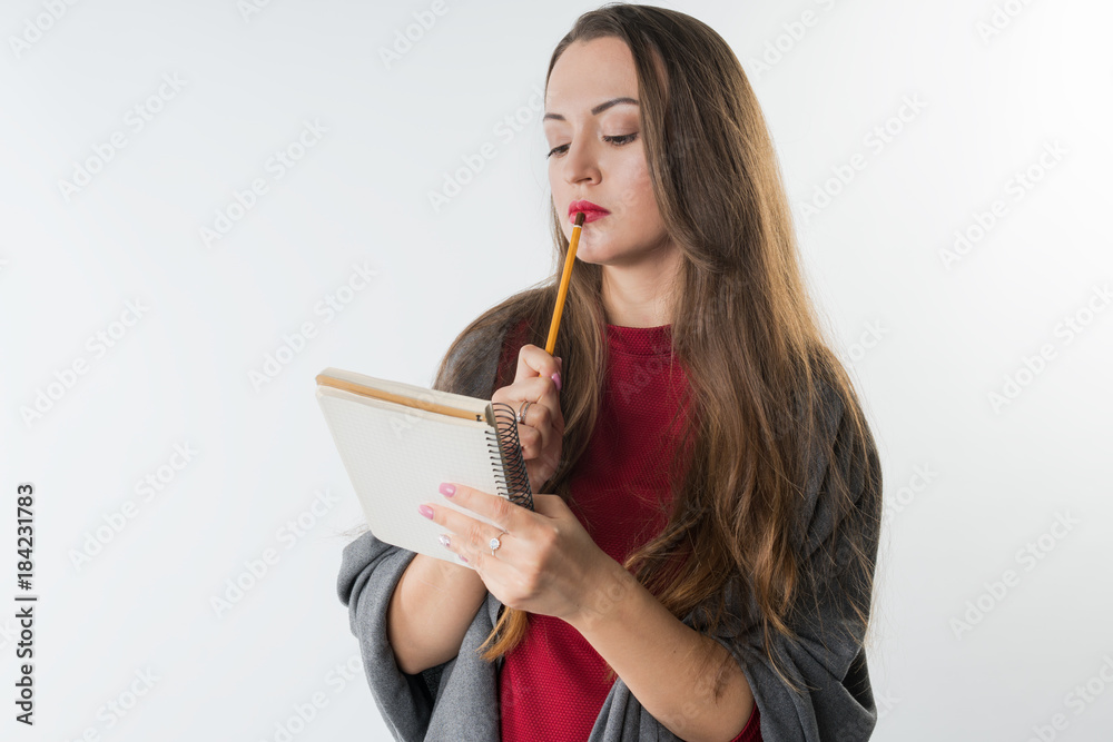 young caucasian female with sketchbook and pencil on white background. She is thinking young caucasian female with sketchbook and pencil on white background. She is thinking