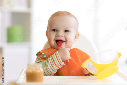 Happy infant baby boy spoon...