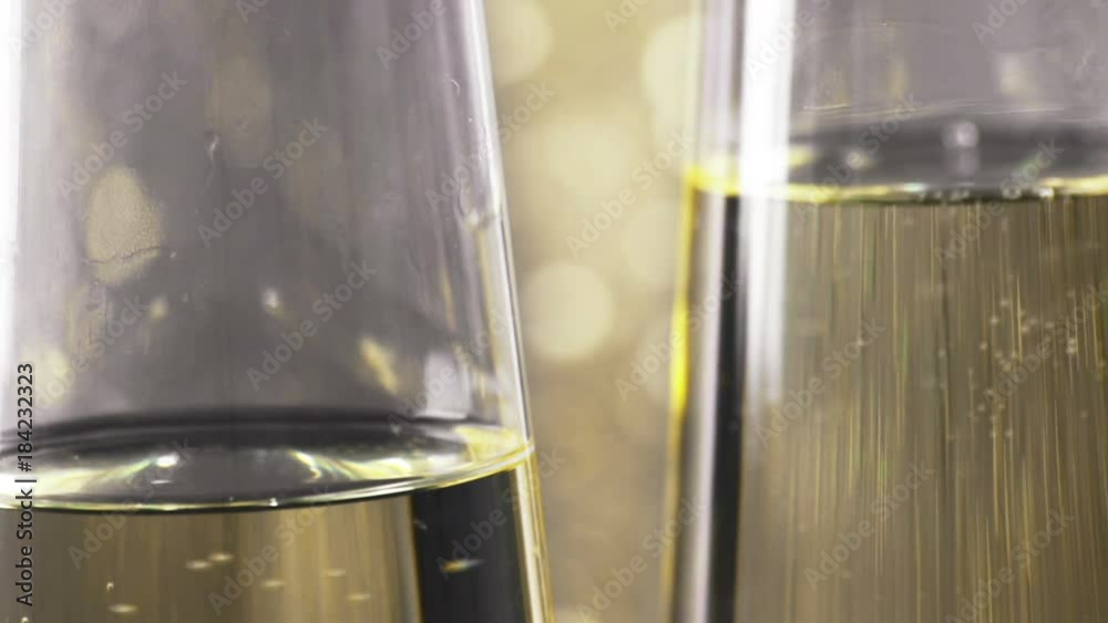 close-up of filling flutes of champagne with golden bubbles against gold bokeh background, concept of golden luxury holiday happy new year event close-up of filling flutes of champagne with golden bubbles against gold bokeh background, concept of golden luxury holiday happy new year event