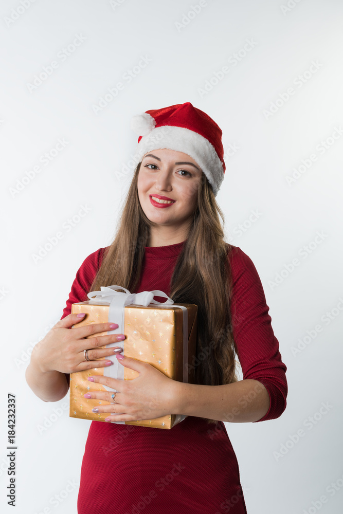 portrait of young christmas woman wearing red santa claus hat with gift isolated on white background, copy space. She looks happy portrait of young christmas woman wearing red santa claus hat with gift isolated on white background, copy space. She looks happy