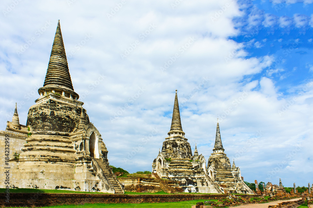 Ancient pagodas on red brick floor step are Ayutthaya, Thailand. This has blue sky be background of picture.