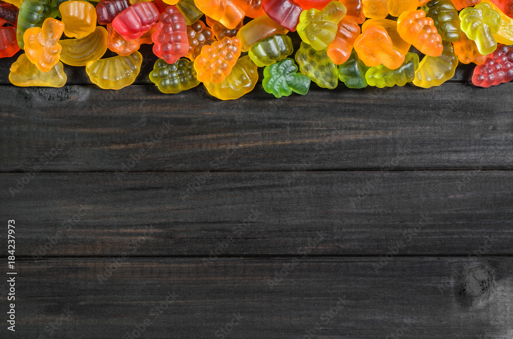 jelly and marmalade candies on a wooden background with free space for text.
