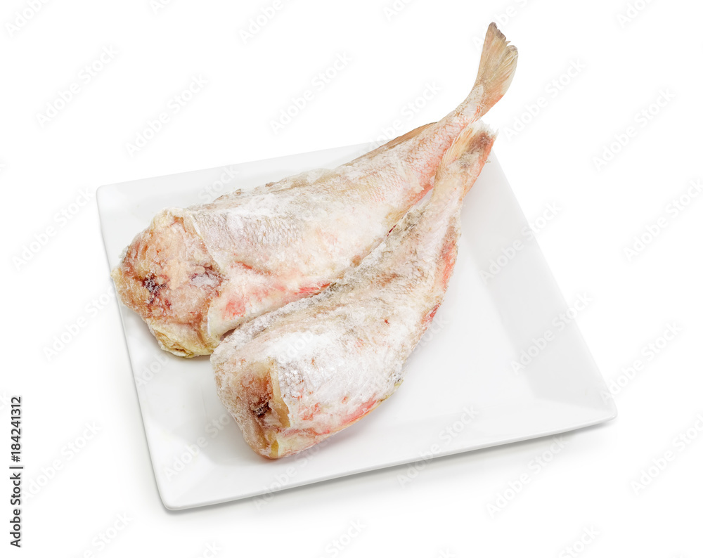Two carcasses of the frozen red cod on white dish Two carcasses of the frozen red cod on white dish
