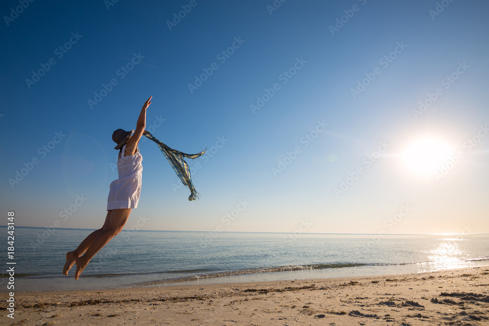 Expressive woman, delighted, jumps on the beach