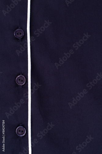 Blue shirt with white edging. Close up on button fasteners. Quality fabric and simple design.