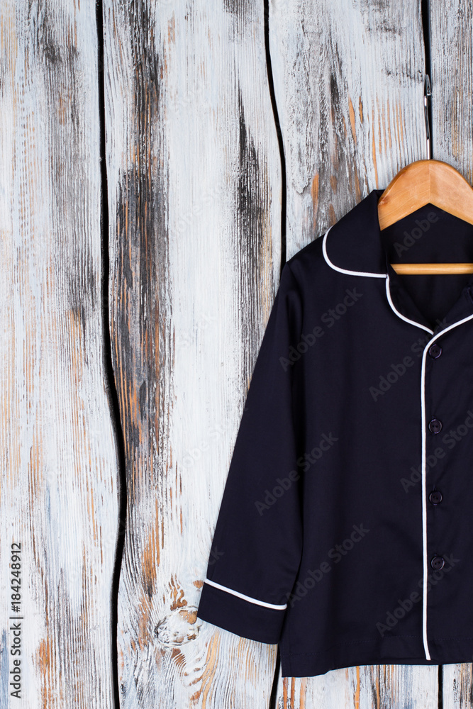 Classic navy pajama shirt. Unisex sleeping garment on wooden hanger. Sleepwear and robes.