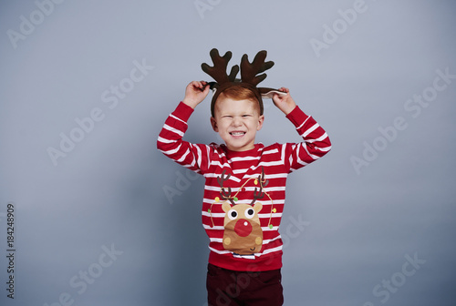 Playful boy with reindeer antlers at studio shot
